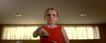 Movie still from “Little Miss Sunshine” (2006), directed by Jonathan Dayton – A little girl holding a remote control in her hand; Close Up shot, Low angle