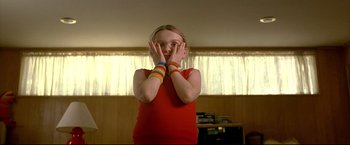 Movie still from “Little Miss Sunshine” (2006), directed by Jonathan Dayton – A young girl in a red shirt is holding her hands up to her face; Close Up shot, Low angle