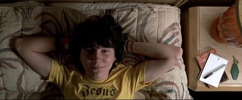 Movie still from “Little Miss Sunshine” (2006), directed by Jonathan Dayton – A person laying in a bed wearing a yellow shirt; Close Up shot, Overhead angle
