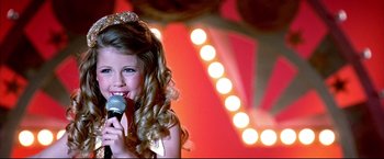 Movie still from “Little Miss Sunshine” (2006), directed by Jonathan Dayton – A little girl that is holding up a microphone; Close Up shot, High angle