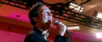 Movie still from “Little Miss Sunshine” (2006), directed by Jonathan Dayton – A man in a tuxedo is singing into a microphone; Close Up shot, Low angle