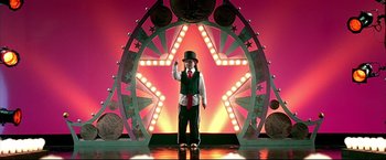Movie still from “Little Miss Sunshine” (2006), directed by Jonathan Dayton – A man in a top hat and vest standing in front of a star; Wide shot, Low angle