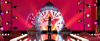 Movie still from “Little Miss Sunshine” (2006), directed by Jonathan Dayton – A person standing in front of a large wheel; Wide shot, Low angle