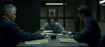 Movie still from “Mindhunter” (2017), directed by Tobias Lindholm – A group of people sitting at a table in a room; Medium shot, Over the shoulder angle