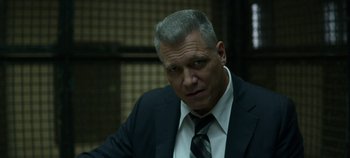 Movie still from “Mindhunter” (2017), directed by Tobias Lindholm – A person wearing a suit and tie; Close Up shot, Low angle