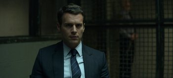 Movie still from “Mindhunter” (2017), directed by Tobias Lindholm – A person wearing a suit and tie; Close Up shot, Low angle