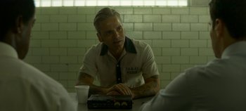 Movie still from “Mindhunter” (2017), directed by Tobias Lindholm – A man sitting in front of a laptop computer on top of a table; Close Up shot, Over the shoulder angle