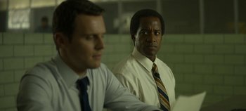 Movie still from “Mindhunter” (2017), directed by Tobias Lindholm – Two men in white shirts and striped ties are looking at the camera; Close Up shot, Over the shoulder angle