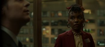Movie still from “Mindhunter” (2017), directed by Tobias Lindholm – A woman in a red jacket and a red bow in her hair; Close Up shot, Over the shoulder angle