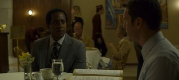 Movie still from “Mindhunter” (2017), directed by Tobias Lindholm – A man sitting at a table in front of a glass of water; Close Up shot, Over the shoulder angle