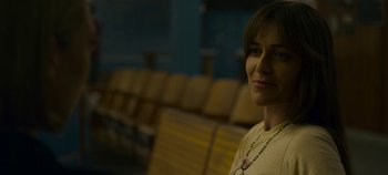 Movie still from “Mindhunter” (2017), directed by Tobias Lindholm – A woman sitting in front of a row of chairs; Close Up shot, Over the shoulder angle