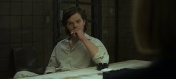 Movie still from “Mindhunter” (2017), directed by Tobias Lindholm – A man sitting at a table with a cigarette in his mouth; Medium shot, Over the shoulder angle