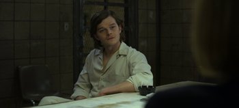 Movie still from “Mindhunter” (2017), directed by Tobias Lindholm – A man sitting at a table in front of a window; Medium shot, Over the shoulder angle