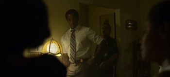 Movie still from “Mindhunter” (2017), directed by Tobias Lindholm – A man in a dress shirt and tie standing next to a man in a police uniform; Medium shot, Over the shoulder angle