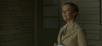Movie still from “Mindhunter” (2017), directed by Tobias Lindholm – A woman in a tan jacket holding a book; Medium shot, Low angle