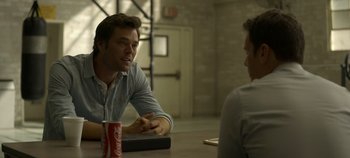 Movie still from “Mindhunter” (2017), directed by Tobias Lindholm – A man sitting at a table talking to another man in front of him; Medium shot, Over the shoulder angle