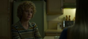 Movie still from “Mindhunter” (2017), directed by Tobias Lindholm – A woman sitting at a table in a kitchen; Close Up shot, Over the shoulder angle