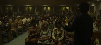 Movie still from “Mindhunter” (2017), directed by Tobias Lindholm – A group of people sitting in front of a crowd of onlookers; Wide shot, High angle