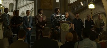 Movie still from “Mindhunter” (2017), directed by Tobias Lindholm – A group of people standing around a podium; Wide shot, Low angle