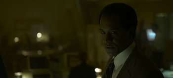 Movie still from “Mindhunter” (2017), directed by Tobias Lindholm – A man wearing a suit and tie in the dark; Close Up shot, Low angle