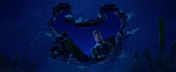 Movie still from “Missing Link” (2019), directed by Chris Butler – A man is looking through a hole in the wall; Medium shot, Low angle