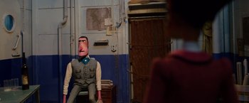 Movie still from “Missing Link” (2019), directed by Chris Butler – A man with a fake nose sitting in a room; Medium shot, Over the shoulder angle