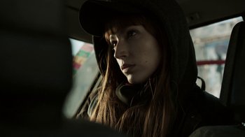 Movie still from “Money Heist” (2017), created by Álex Pina – A woman with long brown hair wearing a black hat; Close Up shot, Low angle