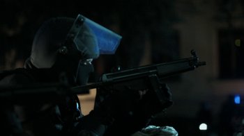 Movie still from “Money Heist” (2017), created by Álex Pina – A person wearing a mask and holding a gun; Medium shot, Low angle