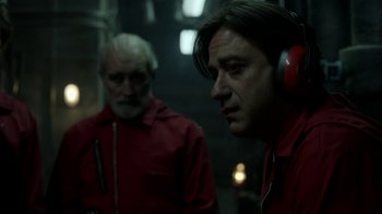 Movie still from “Money Heist” (2017), created by Álex Pina – Two men wearing red jackets and red ear muffs; Close Up shot, Over the shoulder angle