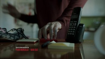 Movie still from “Money Heist” (2017), created by Álex Pina – A person is working on a cell phone on a desk; Extreme Close Up shot, Low angle