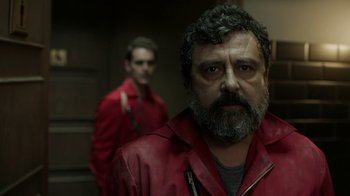 Movie still from “Money Heist” (2017), created by Álex Pina – A man with a gray beard wearing a red jacket; Close Up shot, Low angle