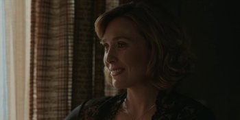 Movie still from “Love & Death” (2023), directed by Clark Johnson – A person wearing a dress smiling; Close Up shot, Over the shoulder angle