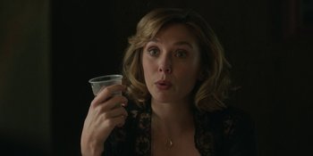 Movie still from “Love & Death” (2023), directed by Clark Johnson – A person holding a drink; Close Up shot, Over the shoulder angle