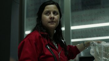 Movie still from “Money Heist” (2017), created by Álex Pina – A woman in a red jacket is looking at the camera; Close Up shot, Low angle