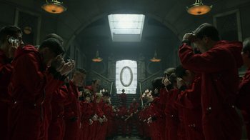 Movie still from “Money Heist” (2017), created by Álex Pina – A group of people standing in front of a staircase; Wide shot, High angle