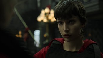 Movie still from “Money Heist” (2017), created by Álex Pina – A woman with short hair wearing a red jacket; Close Up shot, Over the shoulder angle