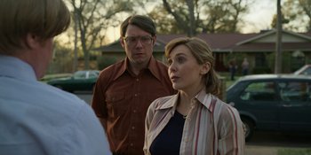 Movie still from “Love & Death” (2023), directed by Clark Johnson – A man and a woman standing next to each other; Medium shot, Over the shoulder angle