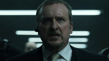 Movie still from “Money Heist” (2017), created by Álex Pina – A person wearing a suit and tie; Close Up shot, Low angle