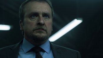 Movie still from “Money Heist” (2017), created by Álex Pina – A person wearing a suit and tie; Close Up shot, Low angle