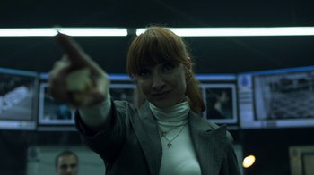 Movie still from “Money Heist” (2017), created by Álex Pina – A woman with red hair is holding something in her hand; Close Up shot, Low angle