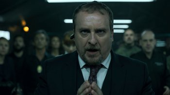 Movie still from “Money Heist” (2017), created by Álex Pina – A person wearing a suit and tie; Close Up shot, Low angle