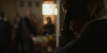 Movie still from “Love & Death” (2023), directed by Clark Johnson – A woman is talking on a phone in a room; Close Up shot, Over the shoulder angle
