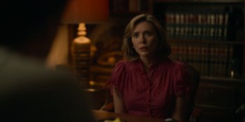 Movie still from “Love & Death” (2023), directed by Clark Johnson – A woman sitting at a table in front of a book case; Medium shot, Over the shoulder angle