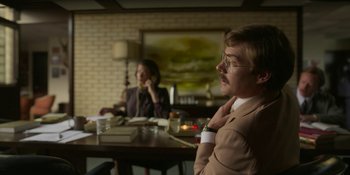 Movie still from “Love & Death” (2023), directed by Clark Johnson – A man and a woman sitting at a dinner table; Medium shot, Low angle