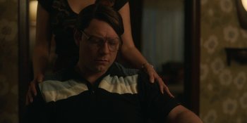 Movie still from “Love & Death” (2023), directed by Clark Johnson – A man sitting in front of a woman with glasses; Close Up shot, Over the shoulder angle