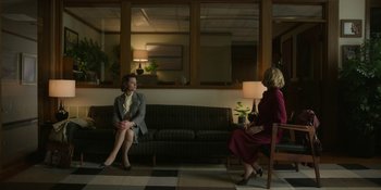 Movie still from “Love & Death” (2023), directed by Clark Johnson – Two women sitting on a couch in front of each other; Wide shot, Over the shoulder angle