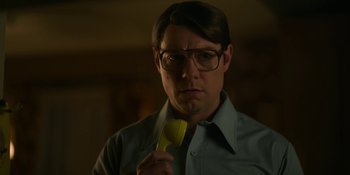 Movie still from “Love & Death” (2023), directed by Clark Johnson – A man holding a piece of paper in his hand; Close Up shot, Low angle