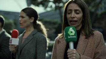 Movie still from “Money Heist” (2017), created by Álex Pina – A woman is crying while holding a microphone in her hand; Close Up shot, Over the shoulder angle