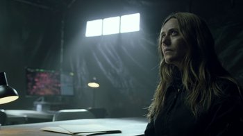 Movie still from “Money Heist” (2017), created by Álex Pina – A woman standing in front of an audience in front of lights; Close Up shot, Low angle