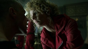 Movie still from “Money Heist” (2017), created by Álex Pina – A woman with curly blonde hair wearing a red jacket; Close Up shot, Low angle